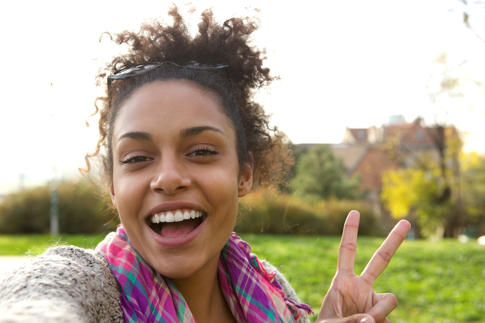 Selfie portrait of a happy young woman with peace sign