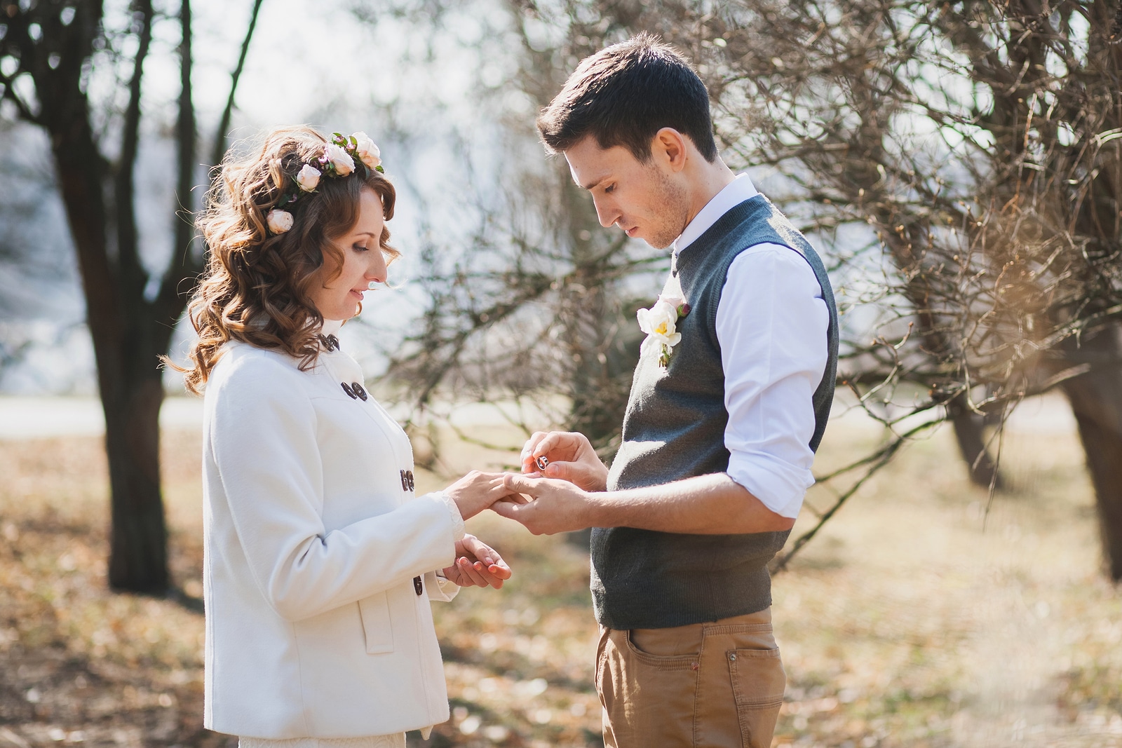Bride and groom exchanging wedding rings. Wedding couple. People in love. Young man and beautiful woman in spring park. Marriage proposal. Outdoors wedding ceremony. Happy people
