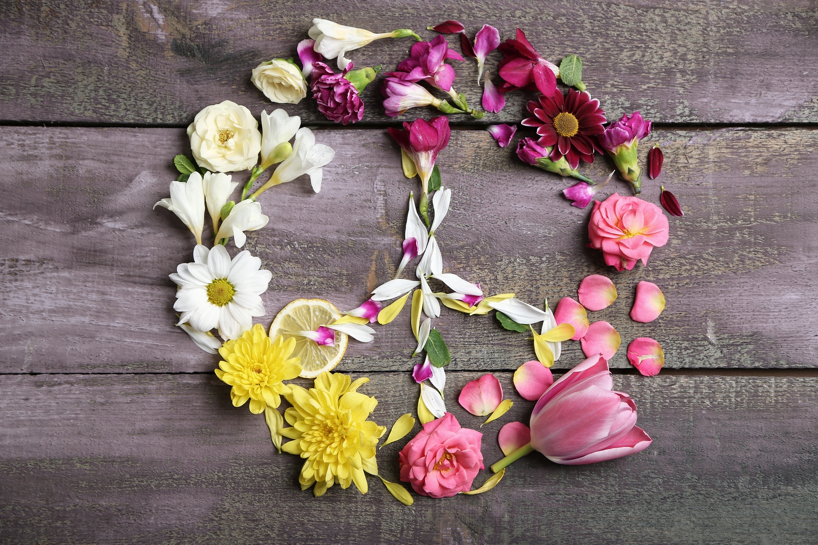 Peace symbol of beautiful flowers, on wooden table