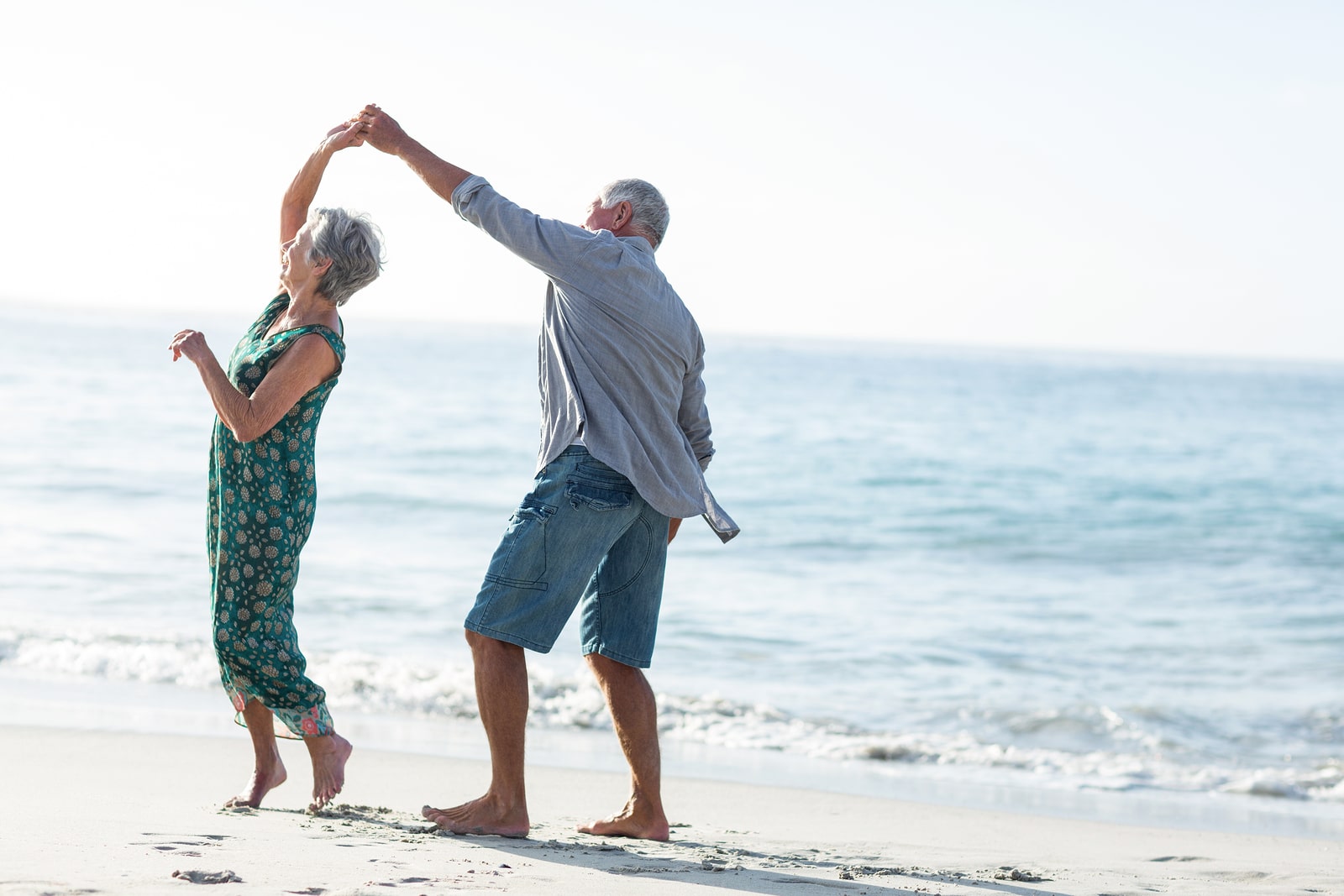 Senior couple dancing at the beach on a sunny day