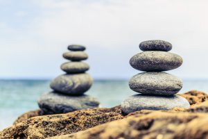 Stones balance and wellness retro spa concept peaceful and unique inspiration zen-like and well being tranquil composition. Closeup of white pebbles stack over blue sea