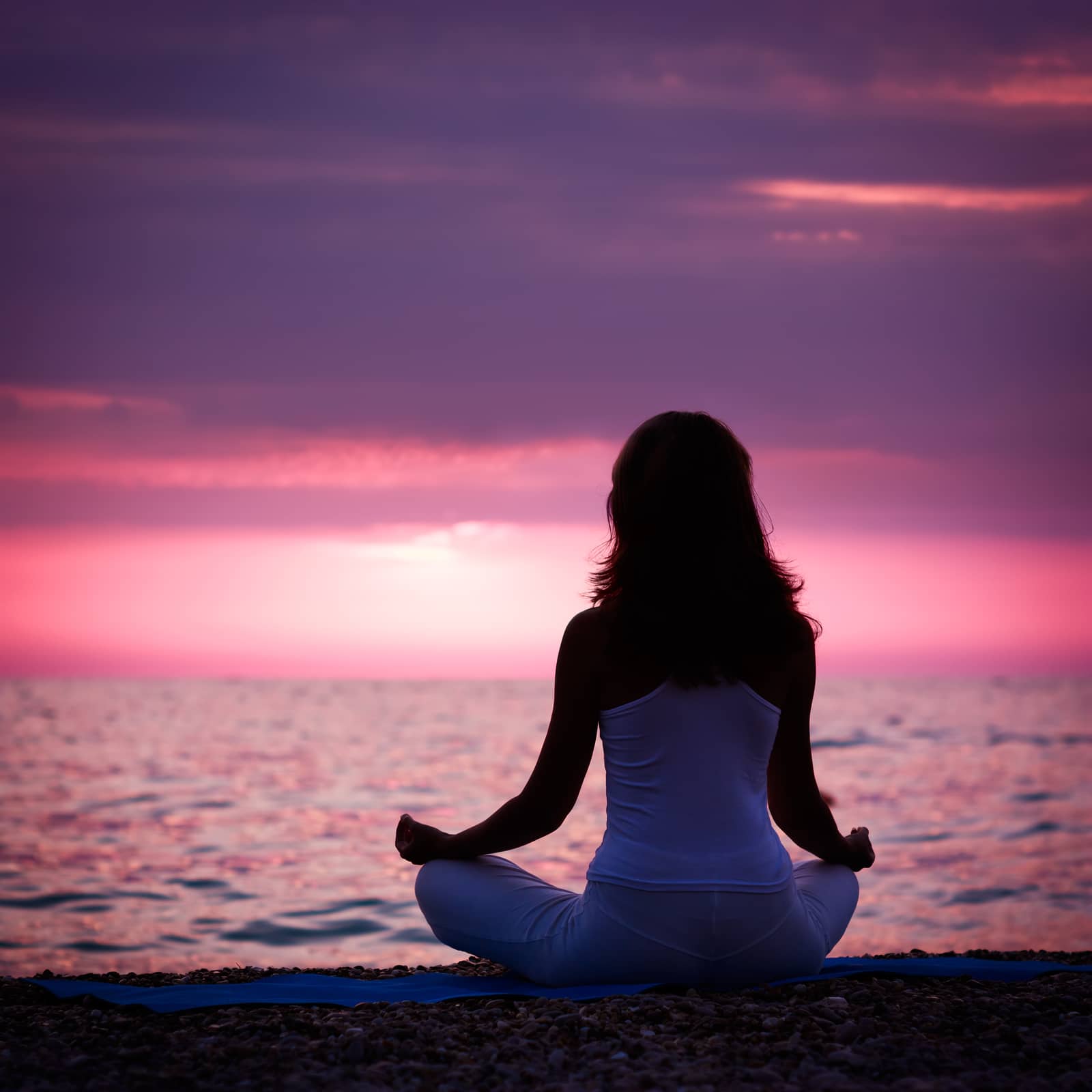 Woman Meditating in Lotus Position by the Sea