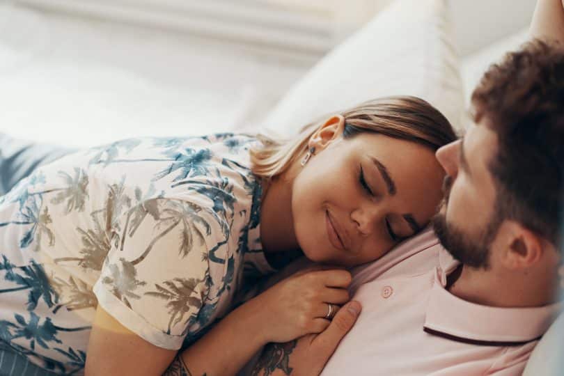 Homem e mulher brancos deitados.