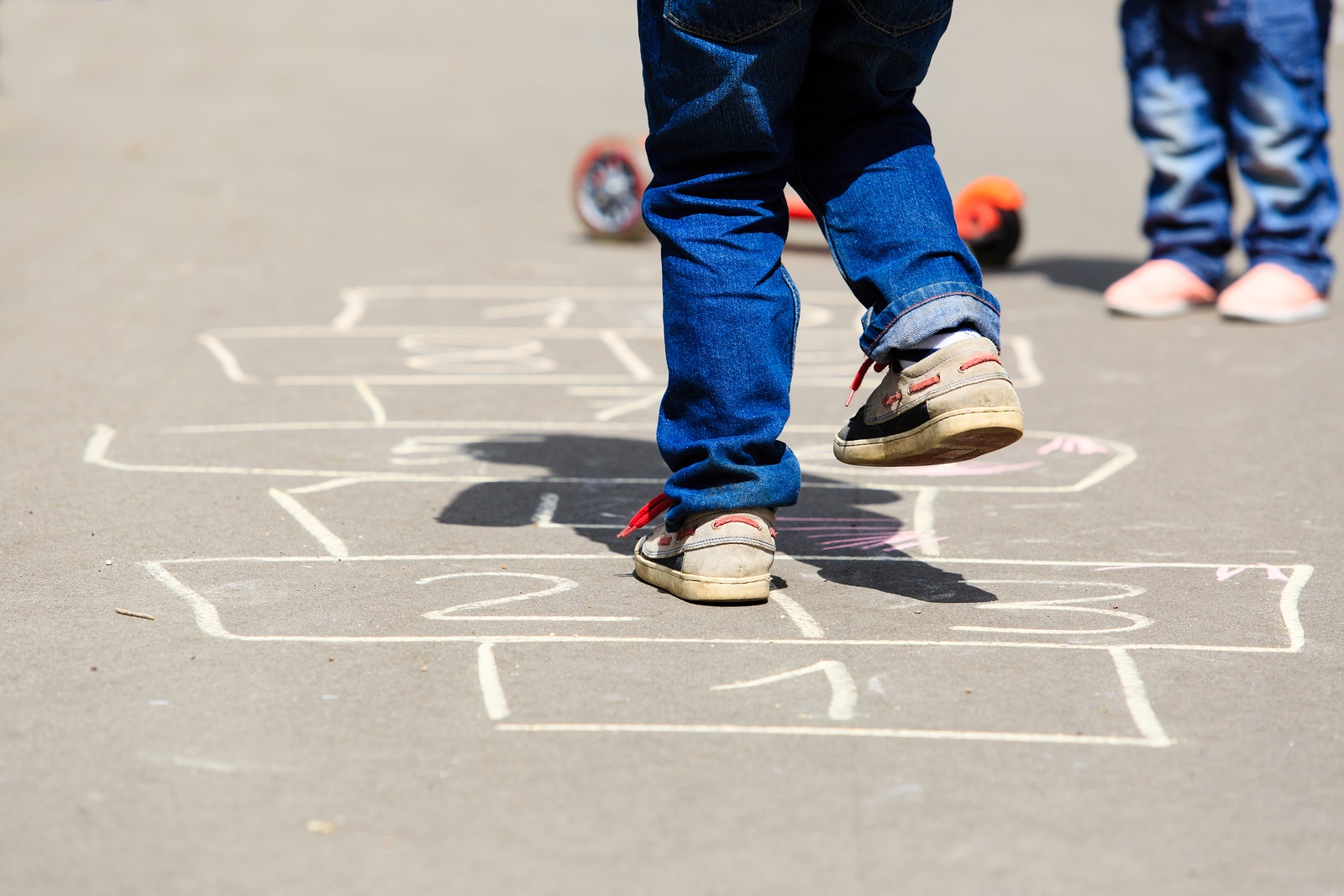 kids playing hopscotch on playground outdoors