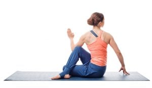 Beautiful sporty fit yogini woman practices yoga asana ardha matsyendrasana - half spinal twist pose isolated on white background