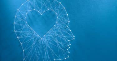 Rede de alfinetes e fios em forma de coração dentro de uma cabeça humana.