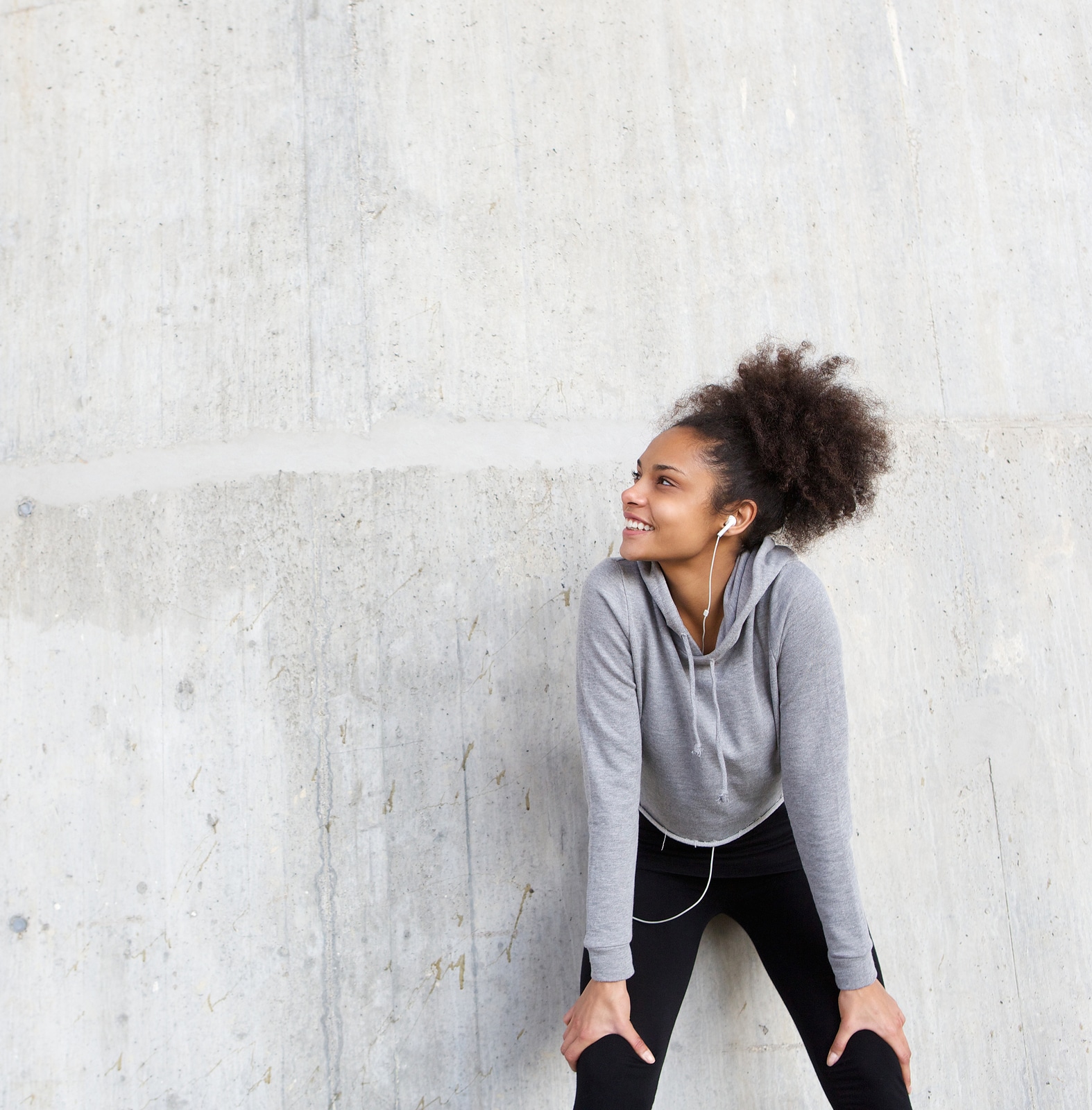 Close up portrait of an attractive young fitness woman smiling with earphones ** Note: Shallow depth of field