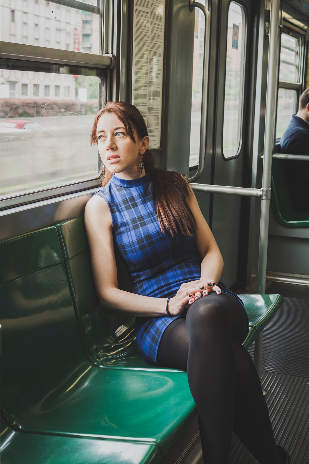 Pensive pretty girl sitting inside subway train