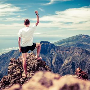 Trail runner man and success in mountains. Motivation and inspiration on mountains peak. Running sports fitness and healthy lifestyle outdoors in summer nature