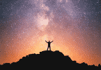 Silhueta de pessoa no topo da montanha observando o céu estrelado