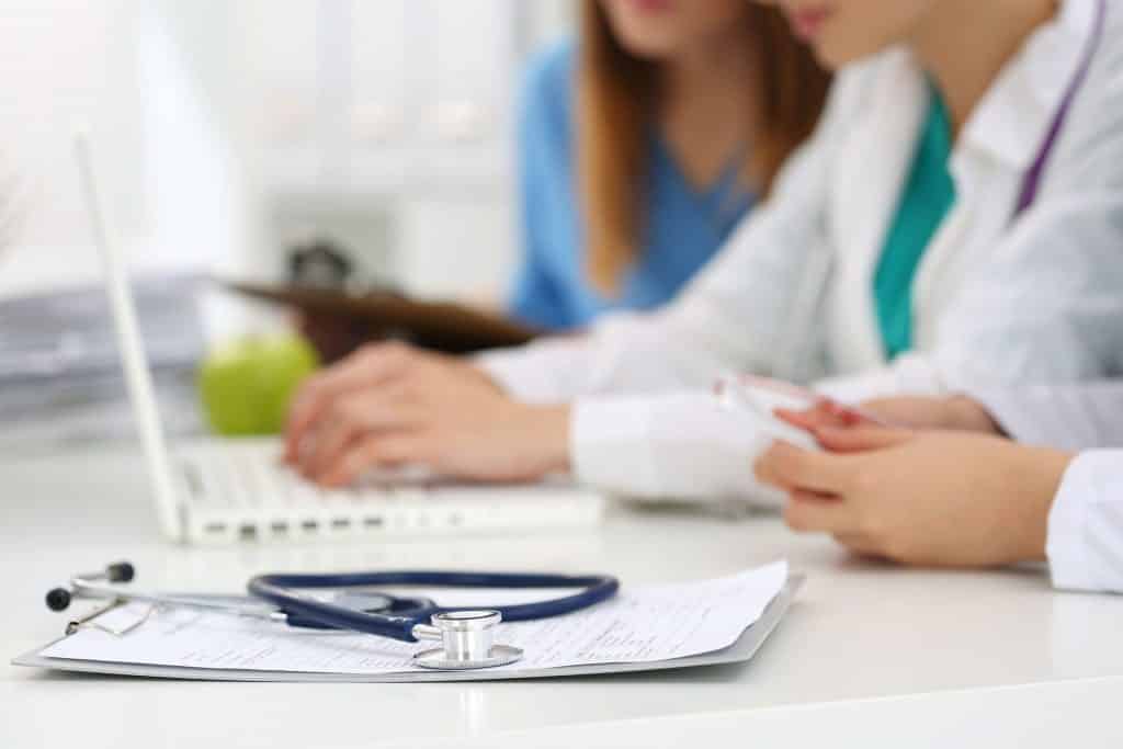 Médicos em uma mesa com notebook