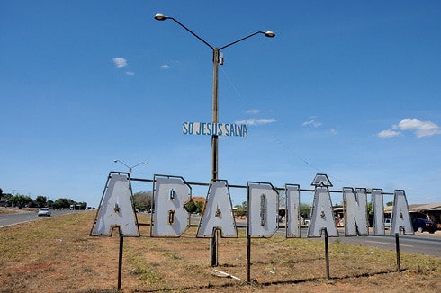 Placa indicando a cidade de Abadiânia, no meio de uma estrada, em Goiás.