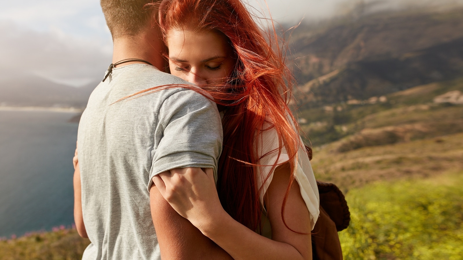 Close up shot of young woman hugging her boyfriend. Young couple in love embracing outdoors.