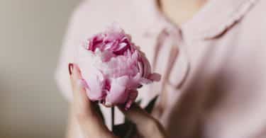 Mulher serandando uma rosa