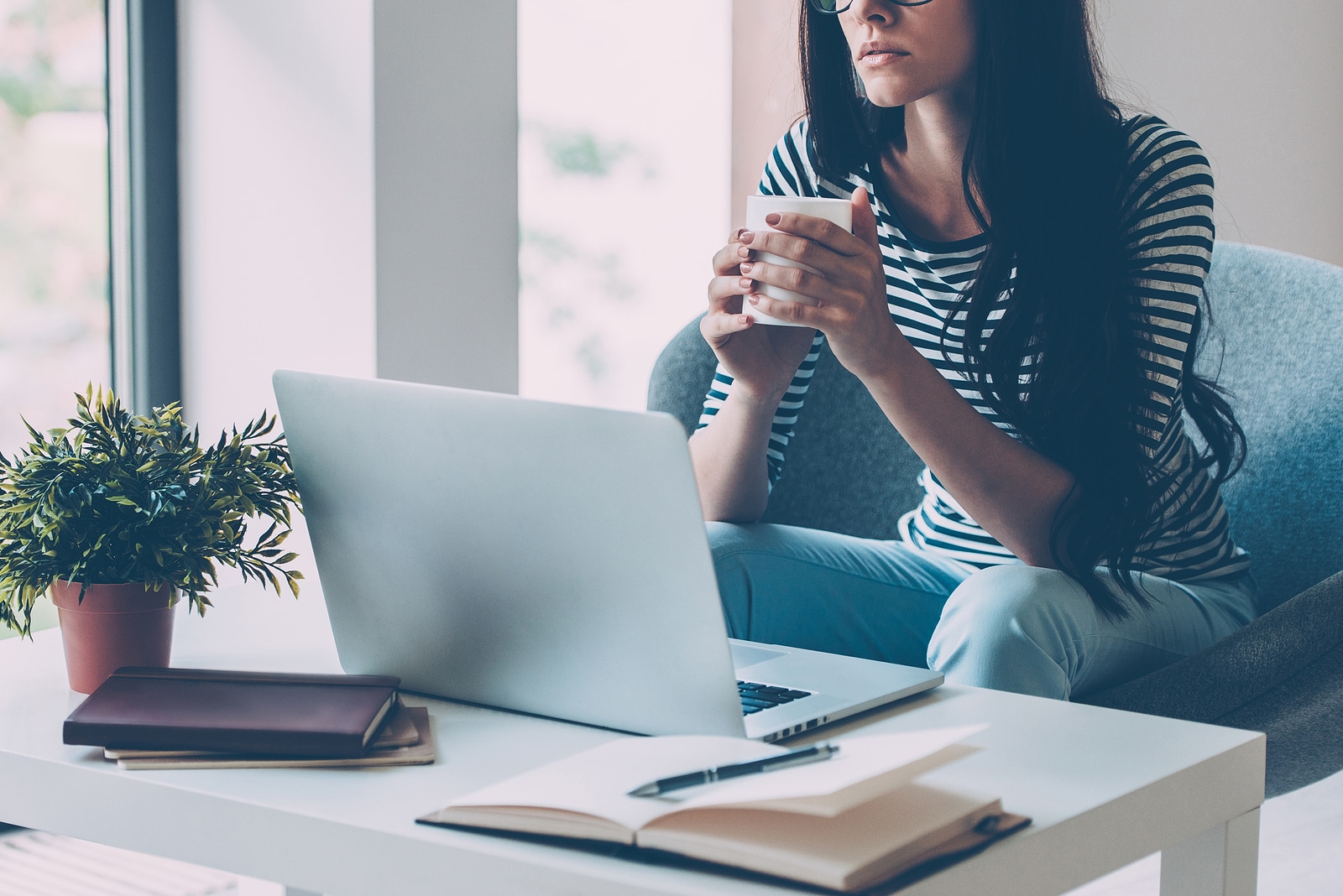 Waiting for inspiration. Close-up of confident young beautiful woman working on laptop and looking at camera while sitting at her working place