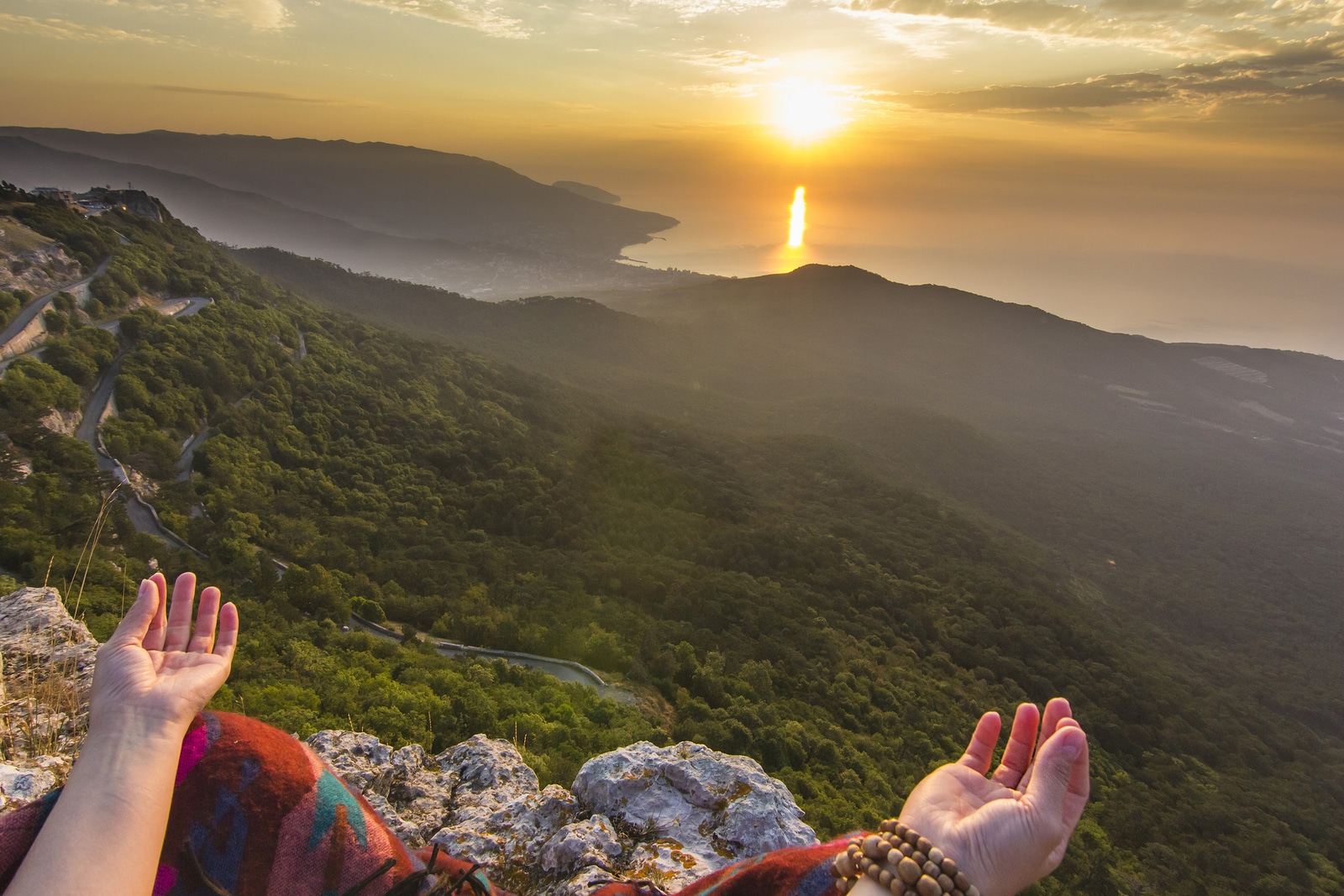 view from eyes of sitting girl in yellow sunrise in mountains above Black sea in Crimea