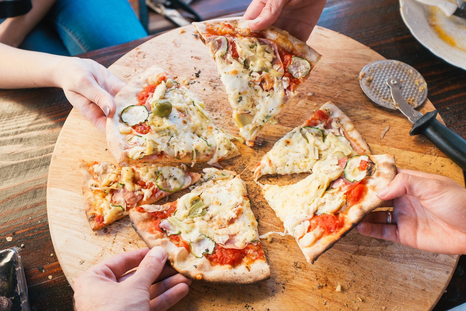 Group of people eating delicious baked pizza