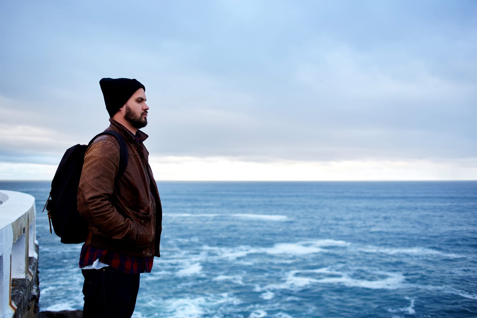 Young sad alone man enjoying beautiful ocean landscape in cool autumn day during his travel ** Note: Soft Focus at 100%, best at smaller sizes