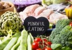 Bancada com carnes e legumes e uma plaquinha preta escrito "mindful eating".