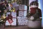 caixas de presentes ao lado de uma árvore de natal