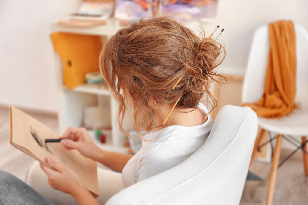 Young female artist drawing sketch in studio