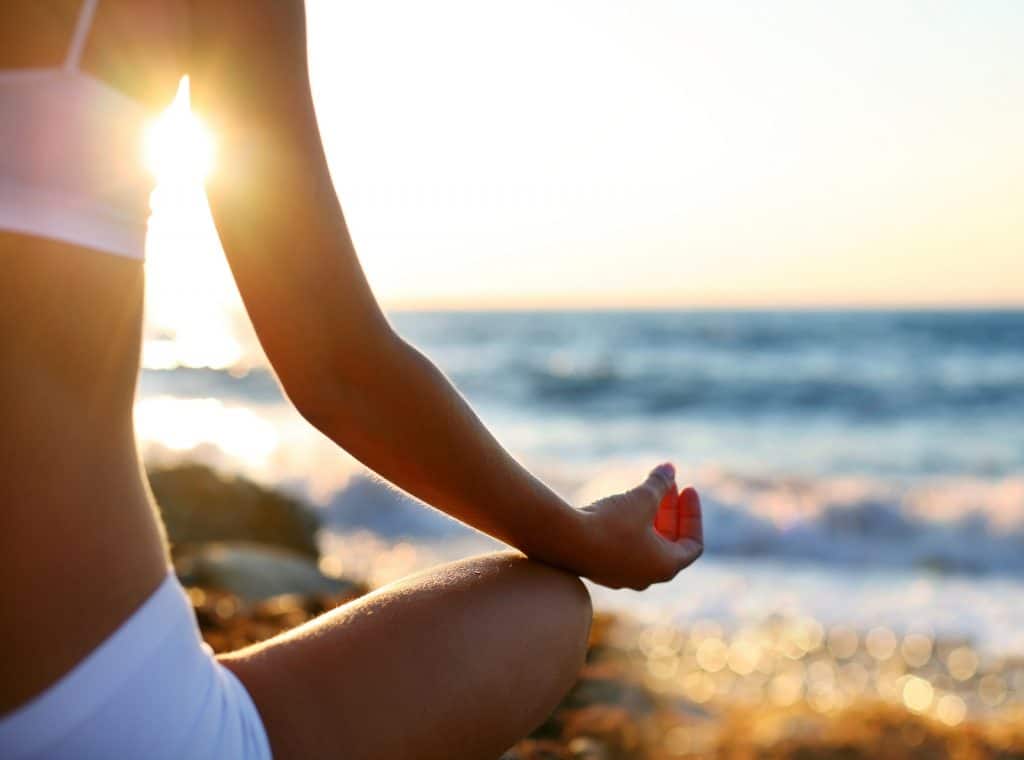 body of a beautiful girl in a meditation on the beach