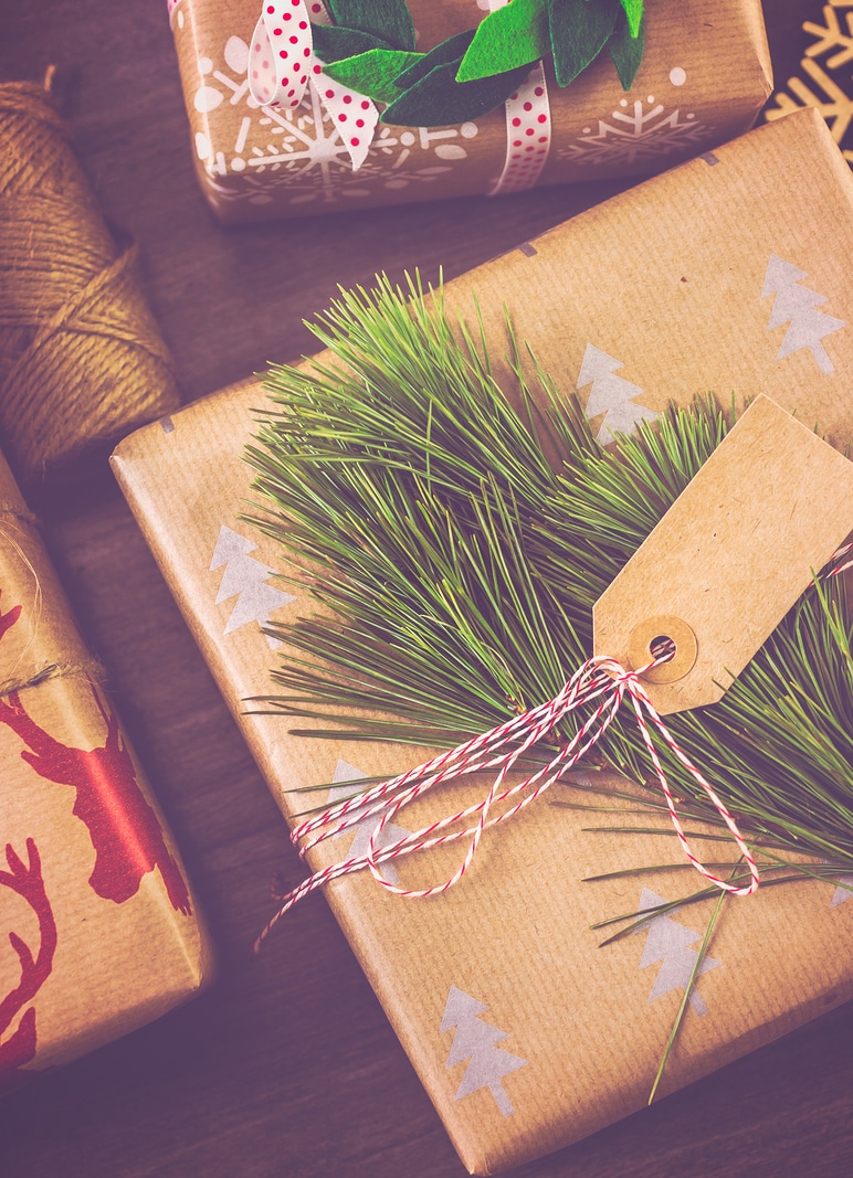 Christmas gifts wrapped in brown paper with red ribbons.