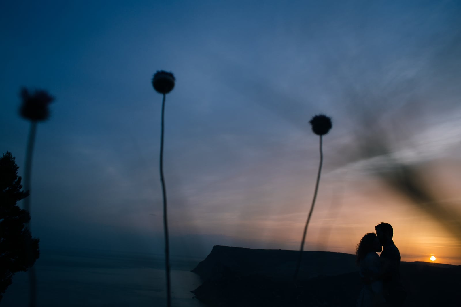 kissing silhouettes against the sky and sunset