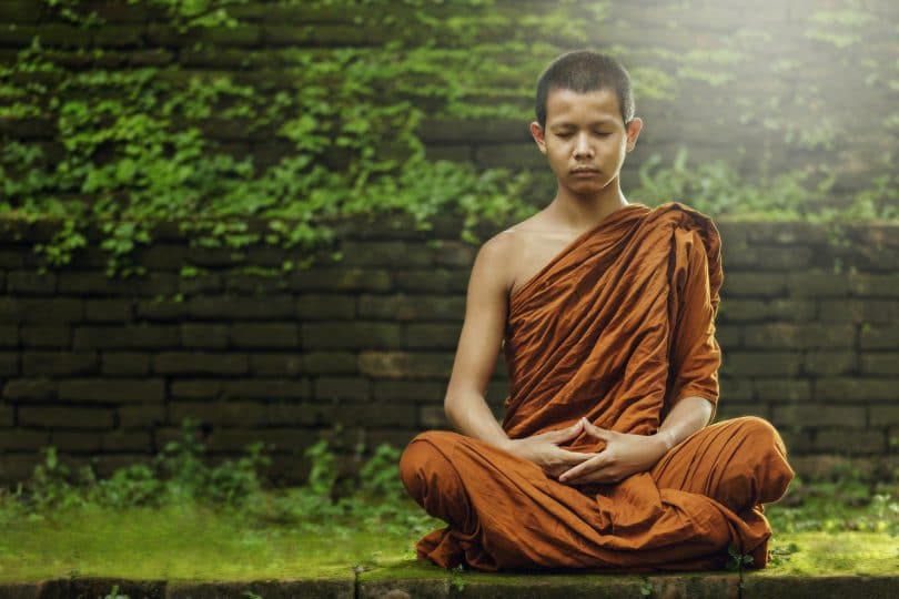 Monge meditando em um gramado