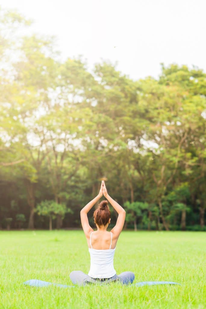 Girl do yoga pose at the park in the morning with sunlight.