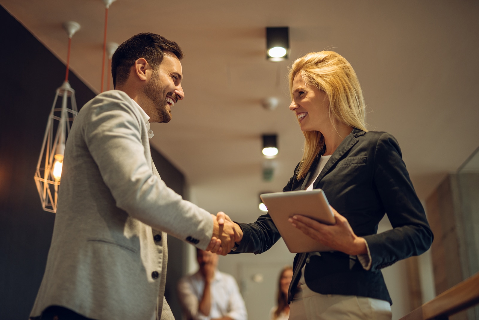 Happy colleagues handshaking while on a meeting in the office.