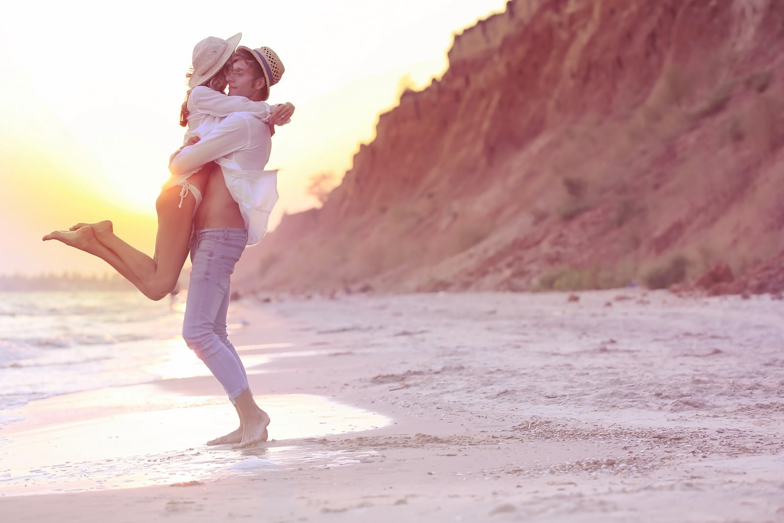 Young happy couple on beach on cliff background