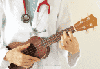 Pessoa de jaleco branco tocando um ukulele