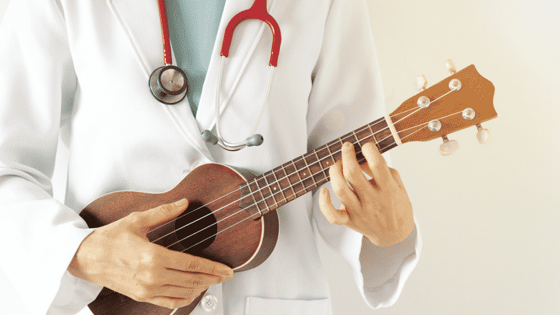 Pessoa de jaleco branco tocando um ukulele