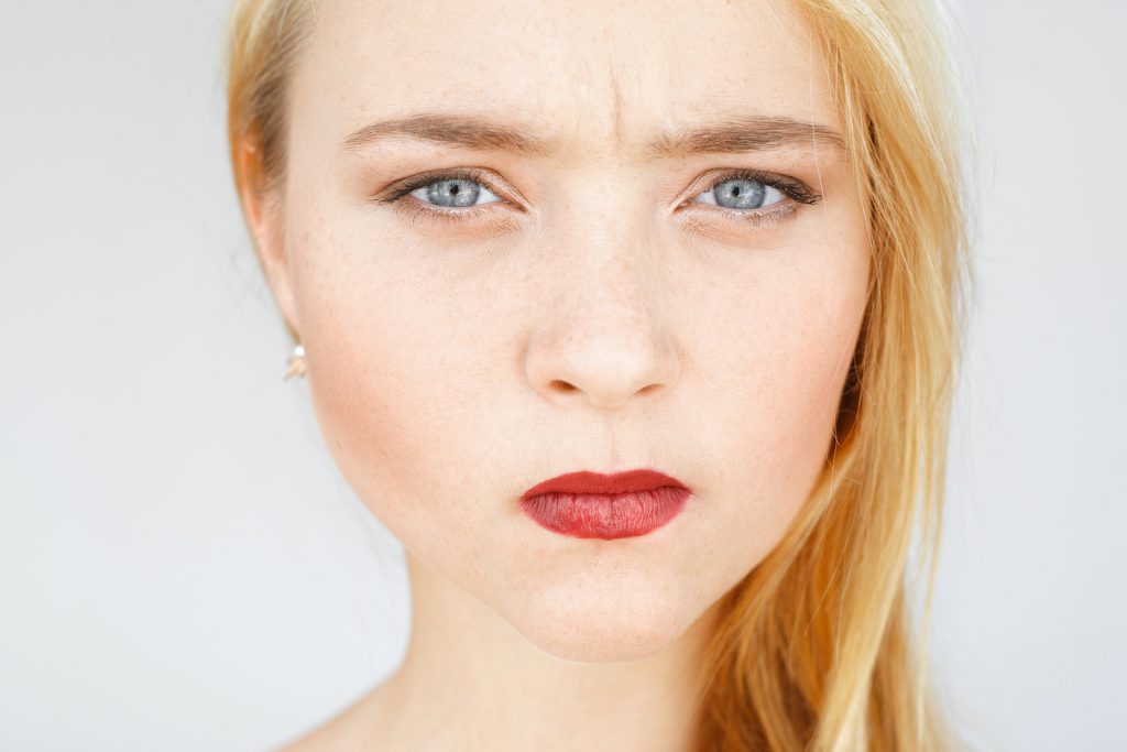 Mulher loira com olhos azuis.