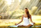 Mulher meditando em um campo aberto.