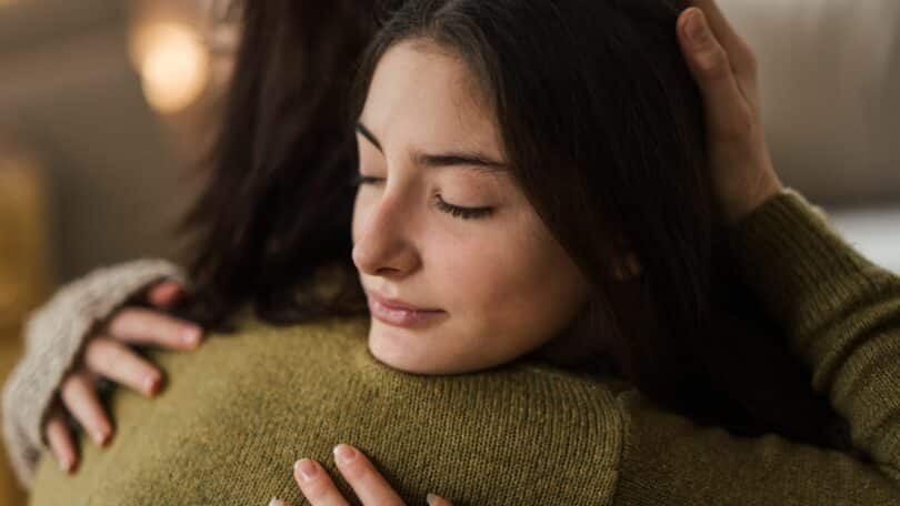 Garota adolescente abraçando sua mãe.