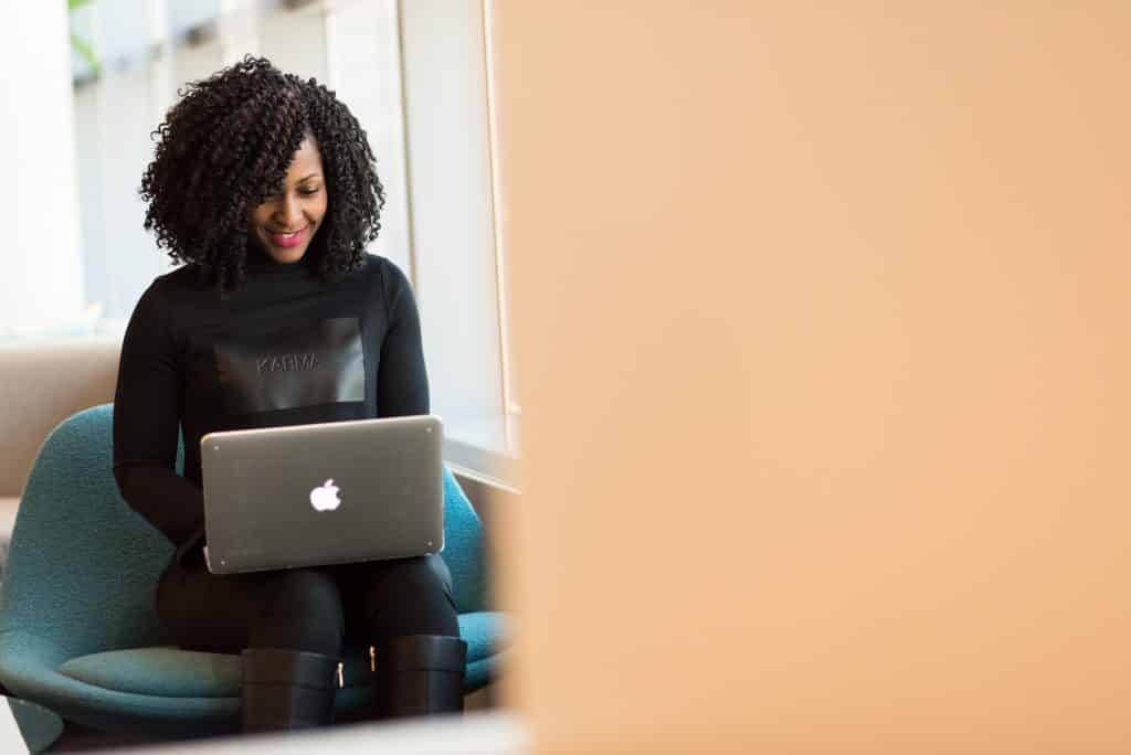 Mulher sentada em ambiente de escritório, usando o computador.