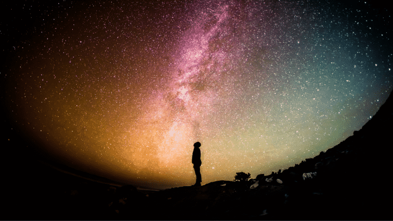 Silhueta de pessoa observando o céu estrelado