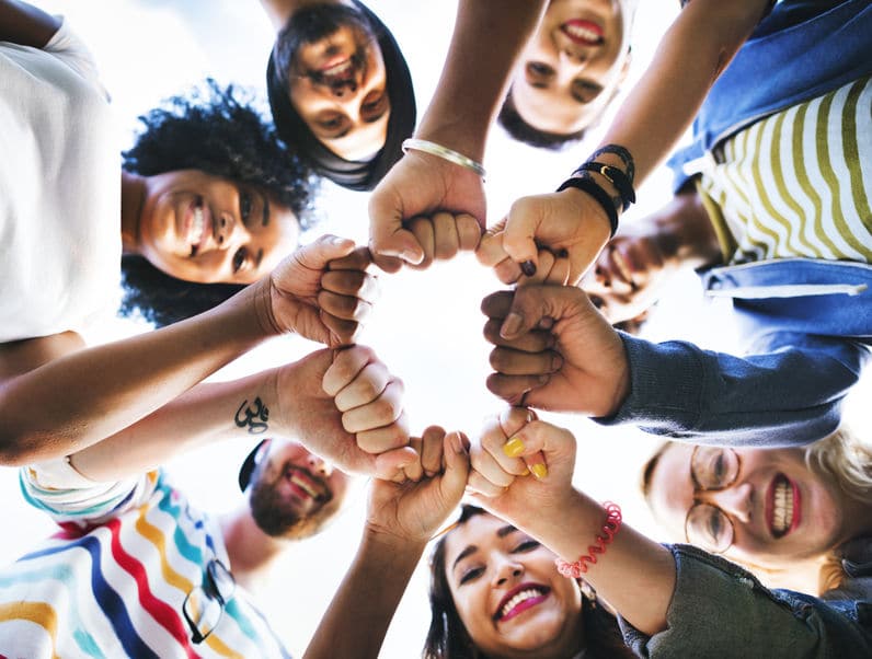 Grupo de amigos com as mãos unidas no centro