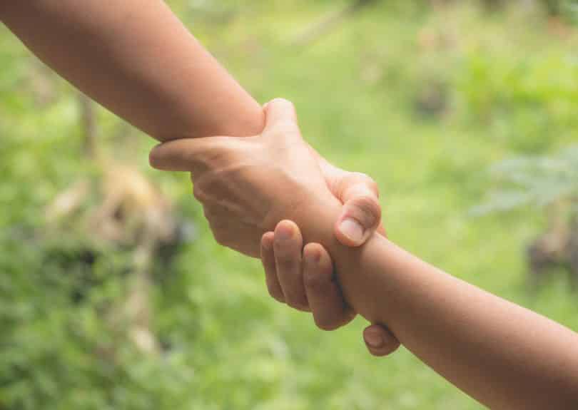 Duas mãos se segurando em simbolismo de ajuda.