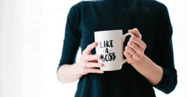 Mulher segurando uma caneca que está escrito em inglês "like a boss"