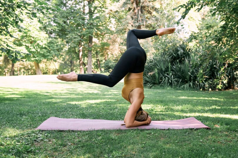 Mulher em posição de Yoga invertida.