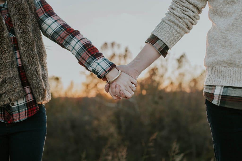 Casal de mãos dadas em um jardim