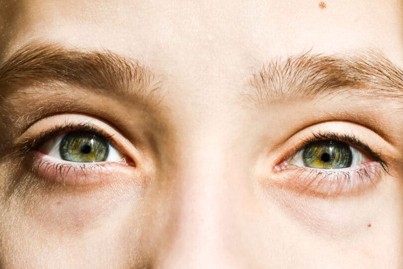 Olhos verdes de uma pessoa jovem.