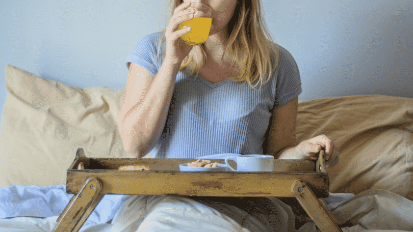 Mulher tomando café da manhã na cama