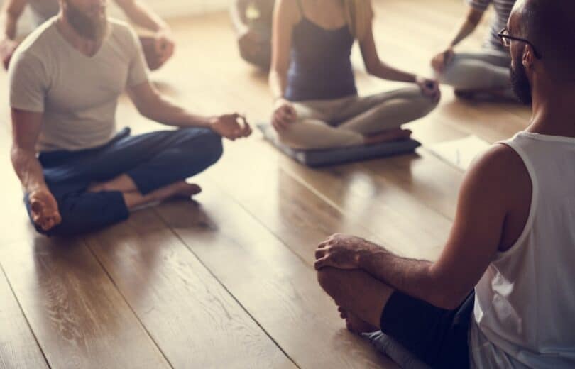 Grupo de pessoas praticando yoga juntos.