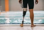 Homem à beira de piscina. Ele tem uma perna protética.