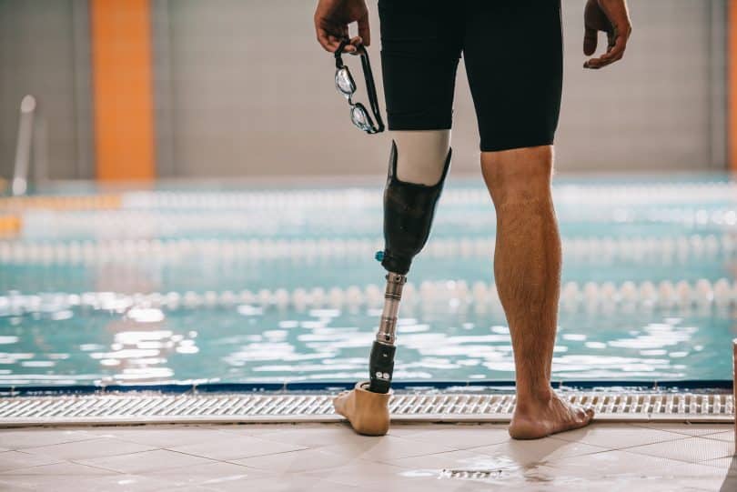 Homem à beira de piscina. Ele tem uma perna protética.