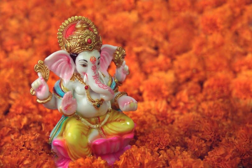 Pequena escultura da Ganesha em umas flores